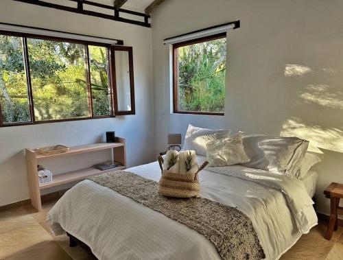 una camera da letto con un letto con una borsa sopra di Casita Icatá con vista a la montaña (A 5 minutos del pueblo) a Villa de Leyva