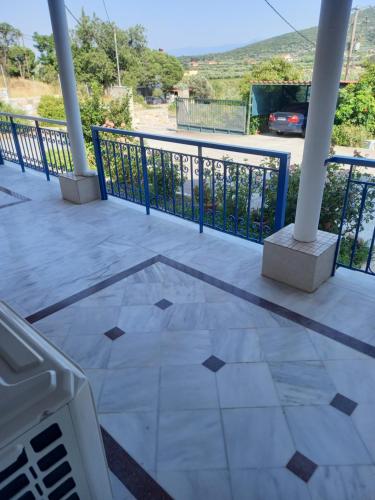 a porch with a tile floor and a railing at Εξοχική κατοικία Αnna's house 