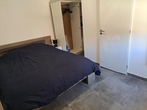 - une chambre avec un lit noir et un placard dans l'établissement Charmant appartement proche des arènes, à Béziers