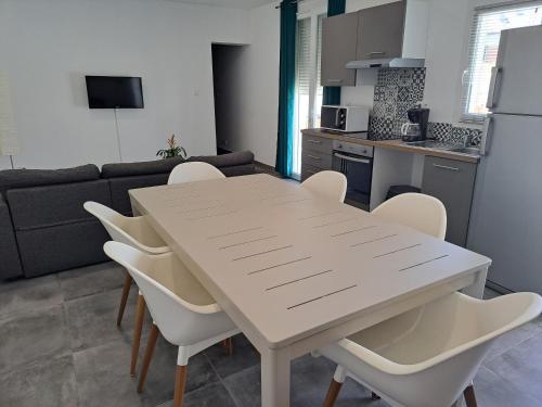 une cuisine et une salle à manger avec une table et des chaises dans l'établissement Charmant appartement proche des arènes, à Béziers