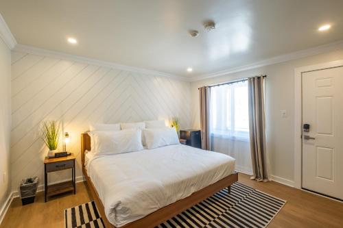 a bedroom with a large white bed and a window at The Surf Club in Ocean City