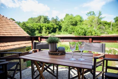a wooden table with two glasses and a potted plant at 1st Truffle House Žumberak in Ozalj
