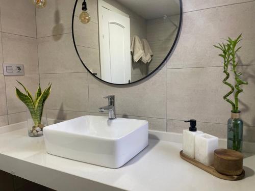 ein Badezimmer mit einem weißen Waschbecken und einem Spiegel in der Unterkunft Apartamento Kai in Playa Jandia
