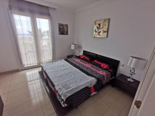 a bedroom with a bed and a large window at Relax and Enjoy in Tenerife Sud! in Chayofa