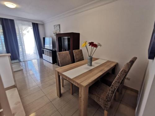 a dining room with a wooden table and chairs at Relax and Enjoy in Tenerife Sud! in Chayofa