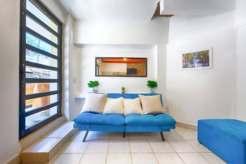 a blue couch in a room with a window at New Sayulita One-Bedroom in Great Location Near Everything in Sayulita