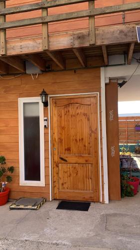 a building with a wooden door and a window at Habitación Rocas del mar in Pichilemu