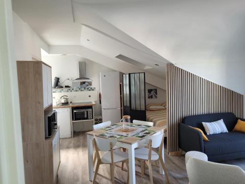 un salon avec une table et un canapé bleu dans l'établissement Appt Pontaillac Vue Océan, à Royan