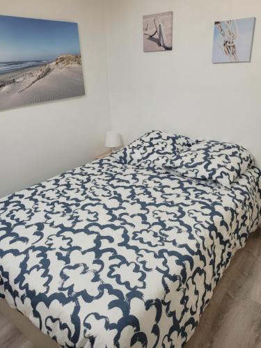 une chambre avec un lit avec une couverture bleue et blanche dans l'établissement Appt Pontaillac Vue Océan, à Royan