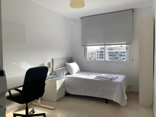 a bedroom with a bed and a desk and a chair at Residencia Universitaria Alfil in Málaga