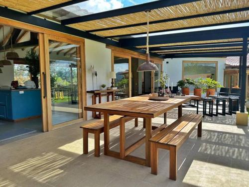 een houten tafel en banken op een patio bij Casa Araní - Vista espectacular y mucho jardín in Villa de Leyva