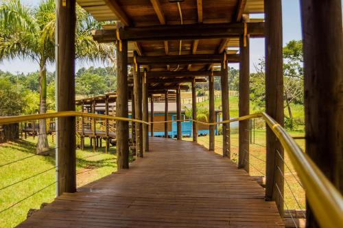 uma passagem de madeira que leva a uma piscina num resort em Hotel Maitei Posadas em Posadas