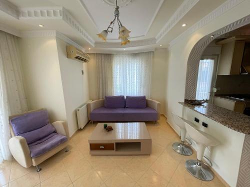 - un salon avec un canapé violet et une table dans l'établissement Family 2bd Flat 150m to the Beach, à Alanya