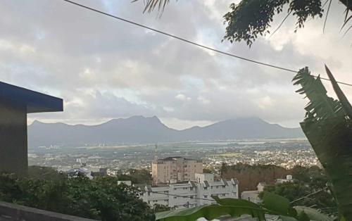 uitzicht op een stad met bergen op de achtergrond bij House in curepipe in Curepipe