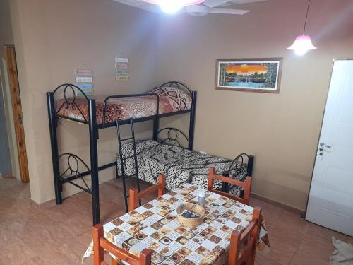 a room with a table and two bunk beds at Linda vista in Arroyo de Los Patos