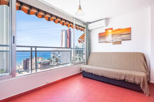 ベニドルムにあるDucado 10-J Apartment Levante Beachのソファと大きな窓が備わる客室です。