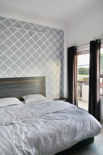 a bedroom with a bed with a blue and white wall at Aarambh Residency in Khajurāho