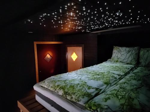 a bedroom with a bed with lights on the ceiling at Relax & Recharge - a Unique Suite with a Touch of Luxury - Hot Tub and Sauna Inspired Decor #NOT A REAL SAUNA# Easy City Access - direct train 15 min to city in Helsinki