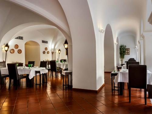 a dining room with white tables and black chairs at Pousada Castelo de Alvito in Alvito