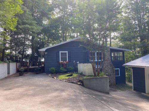 una pequeña casa azul con una entrada delante de ella en Mae’s Cottage in the Clouds en Blue Ridge