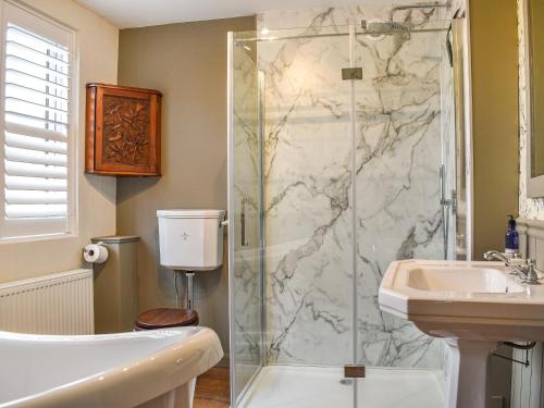 a bathroom with a shower and a sink at Earsdon Cottage in Ireby