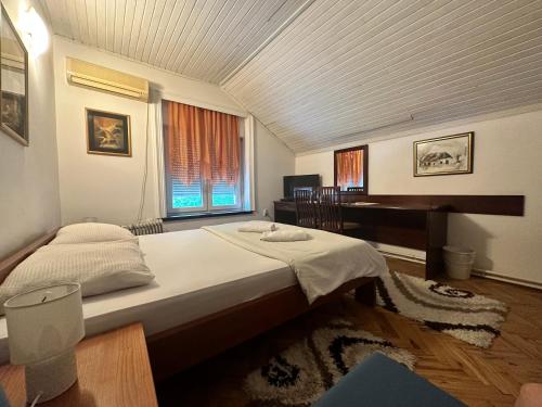 1 dormitorio con cama y escritorio. en Vila Regina, en Palić