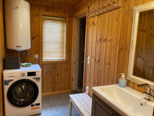 een keuken met een wasmachine en een wastafel bij Golden Seaside Villa in Kärdla