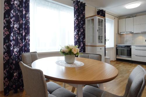 een keuken met een houten tafel met stoelen en een tafel bij Promenaadi Apartment in Võru