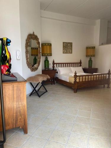 a bedroom with a bed and a table and a mirror at wild rooms&house in Nettuno