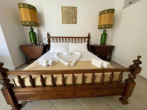 uma cama de madeira com toalhas num quarto em wild rooms&house em Nettuno