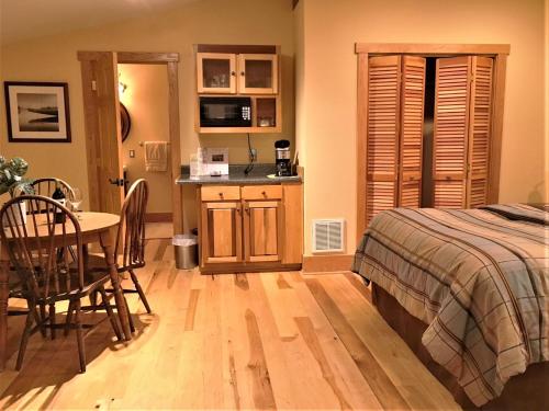 a bedroom with a bed and a table and a kitchen at Heartstone Country Retreat in Buena Vista