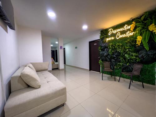 a living room with a couch and a plant wall at Hotel Boutique Veracruz termales in Santa Rosa de Cabal