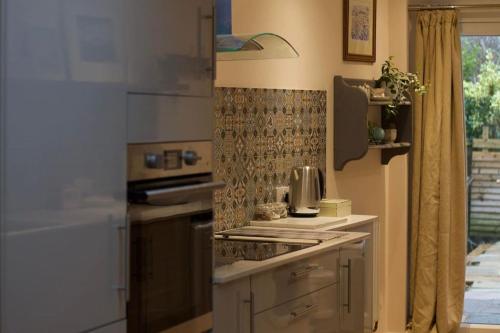 a kitchen with a stove top oven next to a window at Cute Studio with kitchen, patio and free parking in Worthing