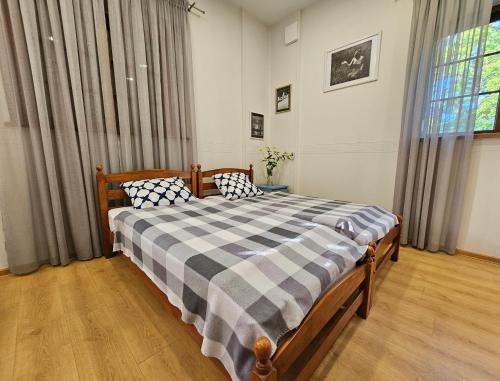 a bedroom with a bed with a checkered blanket at Sodyba Pakrantė in Dituva
