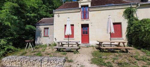 two picnic tables with umbrellas in front of a house at La Graine de Beurre proche zoo de Beauval in Seigy
