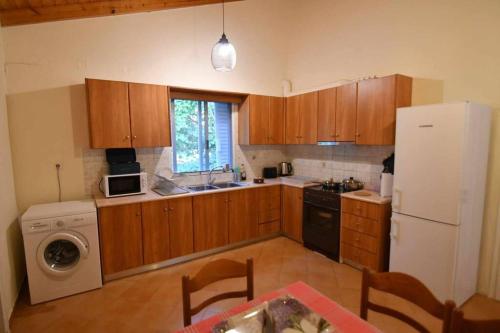 a kitchen with wooden cabinets and a white refrigerator at Cozy Paradise in Preveza