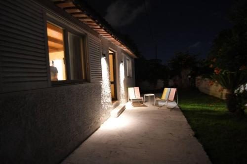 two chairs sitting outside of a house at night at Cozy Paradise in Preveza