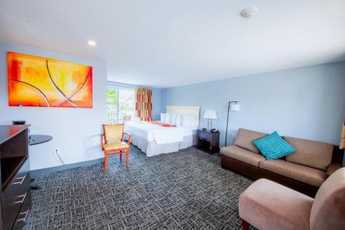 a hotel room with a bed and a couch at Cape Sands Inn in West Yarmouth