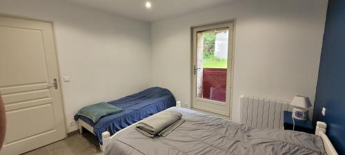 a bedroom with two beds and a window at La Graine de Beurre proche zoo de Beauval in Seigy