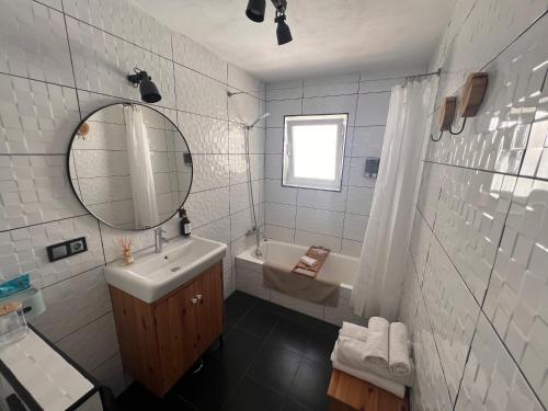 a bathroom with a sink and a mirror and a tub at Casa Olalla in Mijas