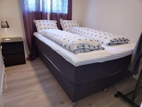 Una cama con almohadas en un dormitorio. en Kjellerleilighet i Fana til leie-med gratis parkering og mange kollektiv reisemuligheter, en Bergen
