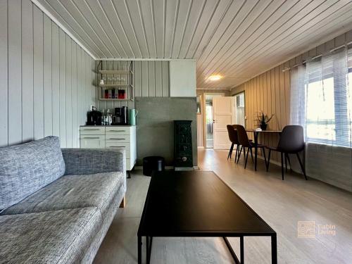 sala de estar con sofá y mesa en Close to nature cabin, sauna, Øyeren view, Oslo vicinity, en Hektner