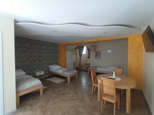 a room with two beds and a table and a dining room at Apartament 592 in Boguszów-Gorce