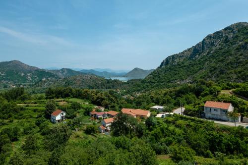 a village on a hill with mountains in the background at Green Hill in Virpazar