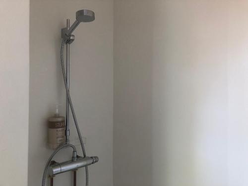 cabezal de ducha en una esquina de una habitación en Helles Have Glamping, en Stege