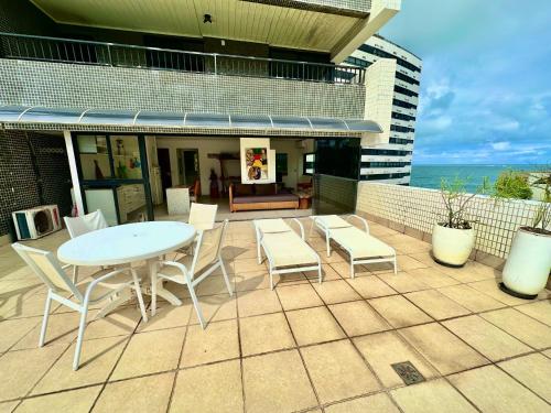 a patio with a table and chairs and the ocean at Ondina Apart Hotel Residences in Salvador