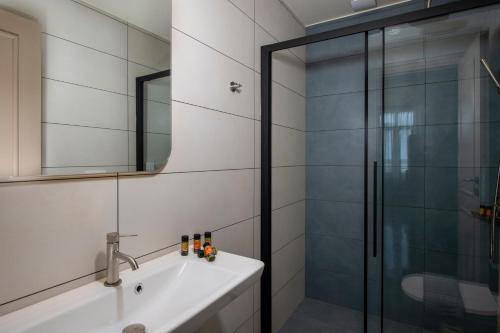 a bathroom with a sink and a shower at Mosaic Venetian Harbour Suites in Chania Town