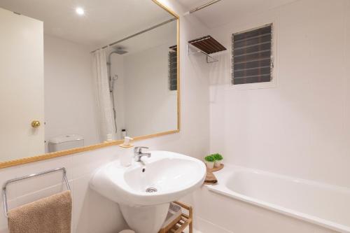 ein Badezimmer mit einem Waschbecken, einer Badewanne und einem Spiegel in der Unterkunft Alcam Tamariu in Palafrugell