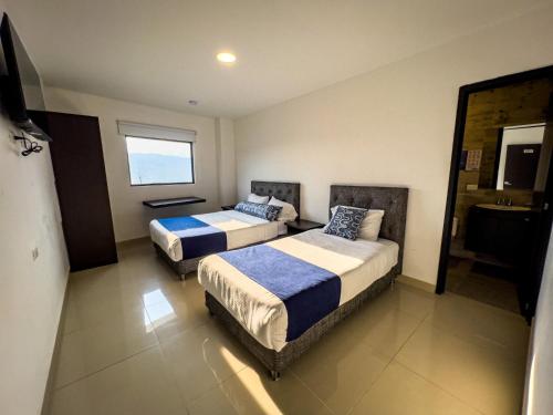 a hotel room with two beds and a window at Hotel Boutique Veracruz termales in Santa Rosa de Cabal