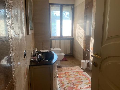 La salle de bains est pourvue de toilettes, d'un lavabo et d'une fenêtre. dans l'établissement Remarkable 6 bedrooms Villa in Cerrione with land, à Cerrione